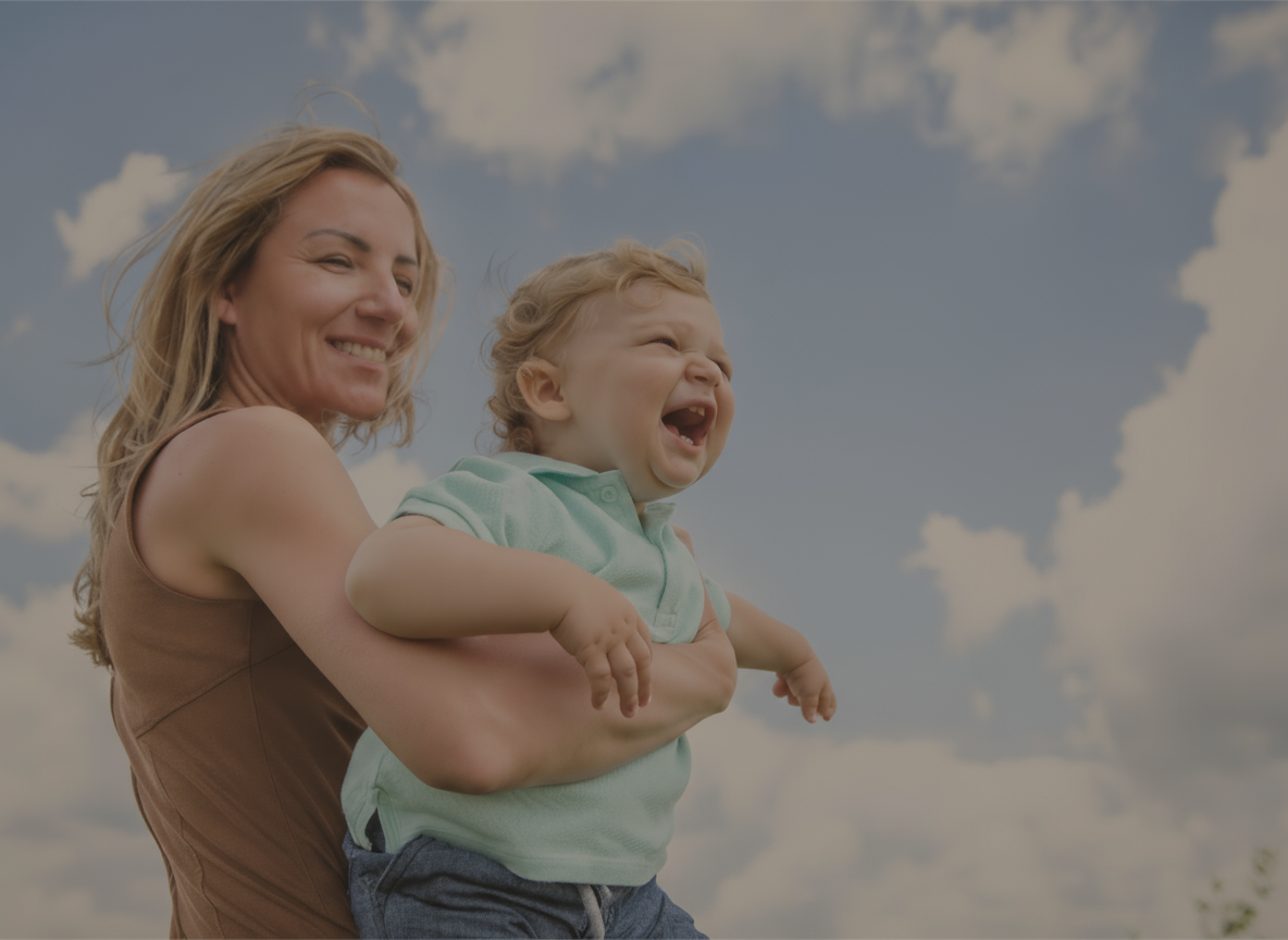 Woman holding a child against a blue sky with clouds